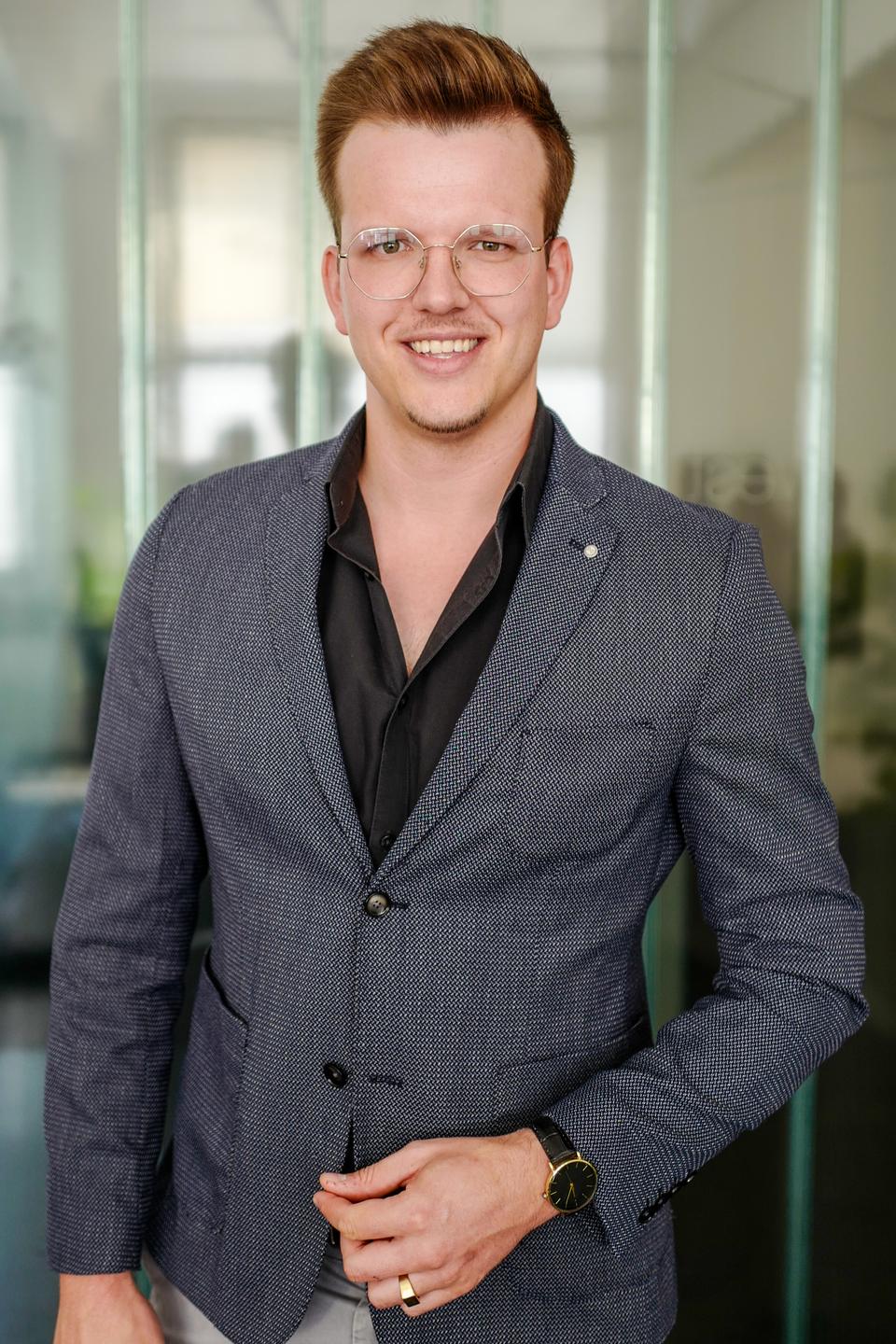 Porträt von Moritz Sauer im grauen Sakko
